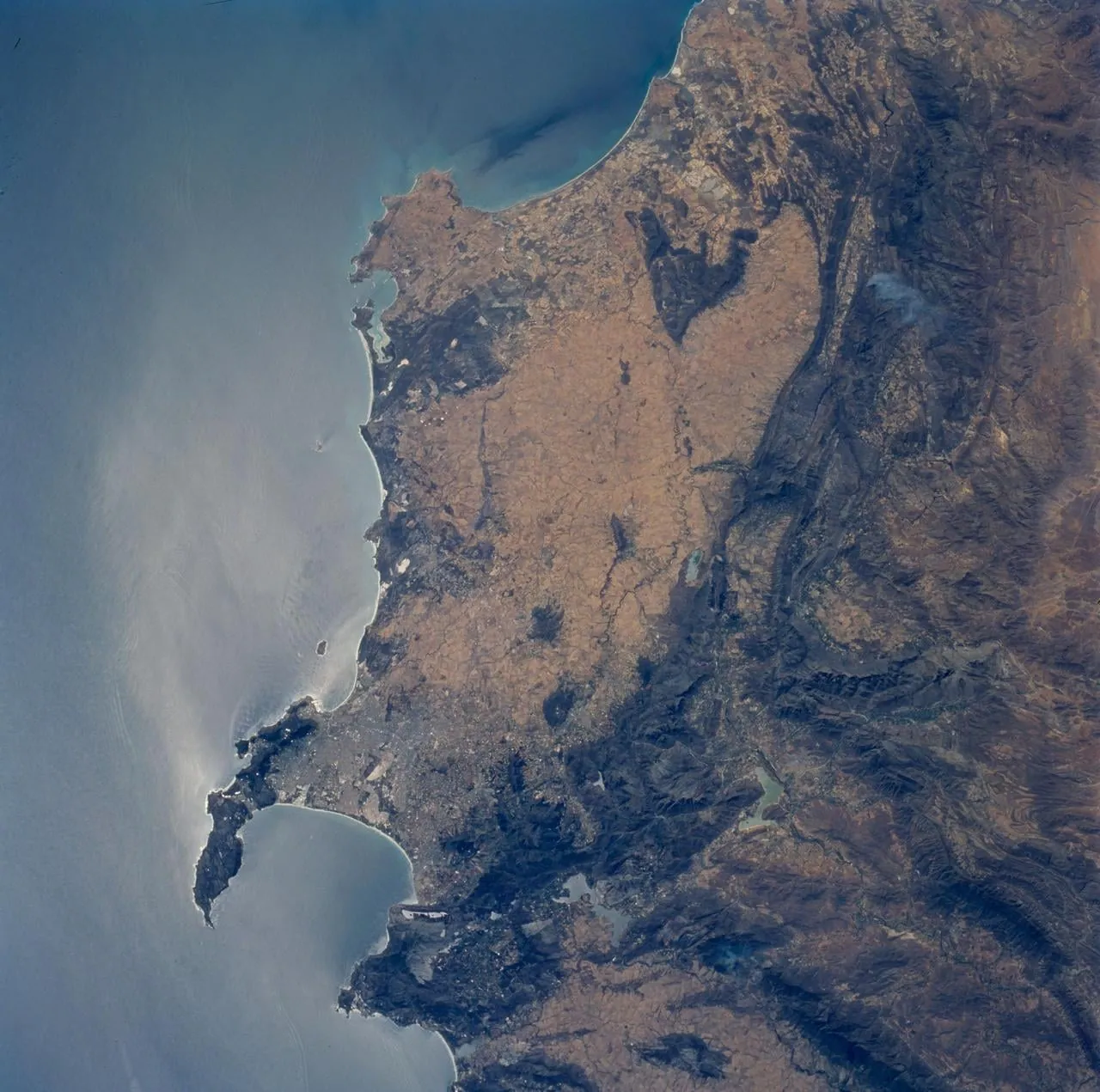 Vista desde el transbordador espacial durante la misión STS-89 con la atmósfera terrestre destacada en el limbo y la superficie de fondo, cuyo subsuelo profundo alberga la biosfera más extensa del planeta.